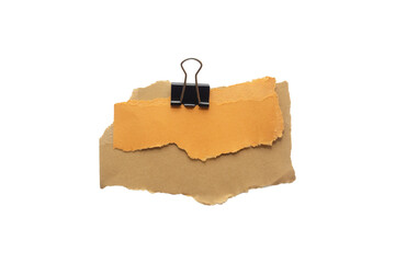 Torn piece of brown and yellow piece of paper with beige tape and black binder isolated on white background