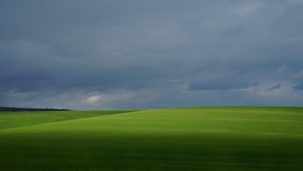 Fototapeta premium Vast green rolling hills under a dramatic stormy sky