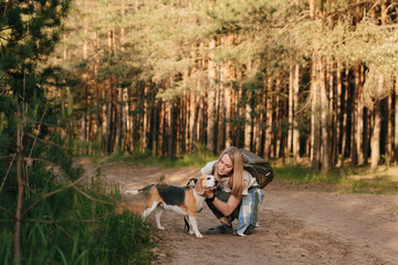 Hiking with beagle in sunlit forest emphasizes companionship and nature