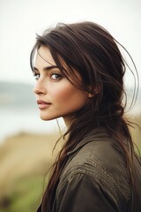 Fototapeta premium Young woman with freckles looking thoughtfully into distance, enjoying outdoors and peaceful landscape, relaxed wellness travel.