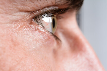 Close-up of a person's eye, showcasing intricate details of the iris and eyelashes.