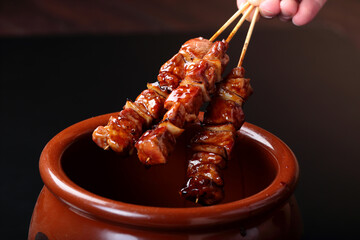 タレ壺の中の焼き鳥のタレに漬ける室蘭やきとりのイメージ