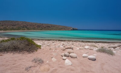 Pristine beach with turquoise water and pale sand.  A tranquil, sunny coastal scene