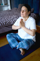 Fototapeta premium a senior woman performs somatic exercises, yoga at home