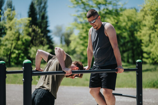 Two individuals performing physical exercises on parallel bars in a sunny outdoor park environment, emphasizing fitness and teamwork. - Powered by Adobe