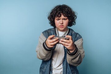 Teen playing mobile game with focused expression
