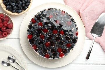 Delicious cheesecake with berries served on white wooden table, flat lay