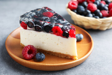 Piece of delicious cheesecake with berries on grey table, closeup