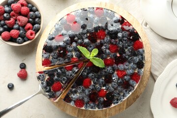 Delicious cheesecake with berries and mint on light grey table, flat lay