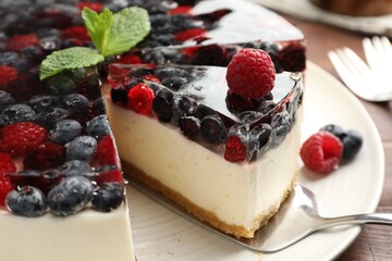 Taking piece of delicious cheesecake with berries at table, closeup