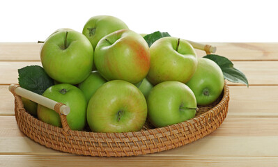 Fresh apples and green leaves on wooden table against white background