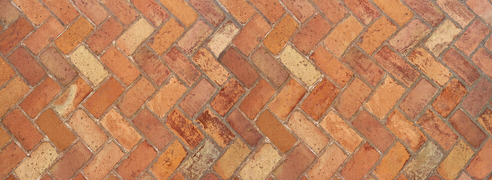 Alte terrakottafarbene Klinkersteine im Fischgr&auml;tmuster - Panorama Hintergrund