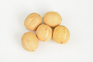 Close-up view of five pecan nuts on a white surface
