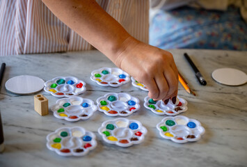 Colorful paint palettes with brushes and pencils on marble table ready for art activity