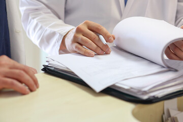 Close-up of a medical record and a doctor's hand with a pen. Treatment plan. Medicine concept.