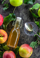 Apple cider vinegar against a background of apples. Selective focus.