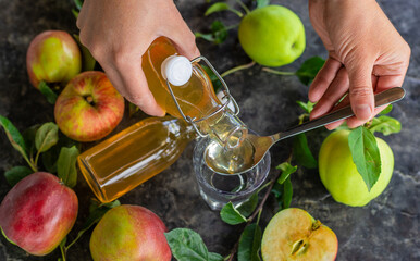 Apple cider vinegar against a background of apples. Selective focus.