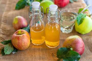 Apple cider vinegar against a background of apples. Selective focus.