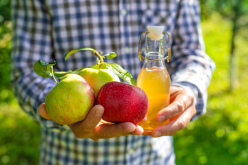 Apple cider vinegar against a background of apples. Selective focus.