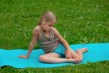 Generation Alpha girl sad on a mat outdoors in the summer