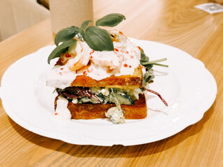 Delicious sandwich with fresh ingredients served on a white plate at a cozy cafe