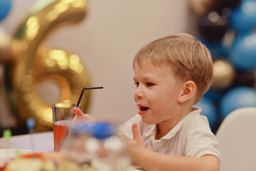 6 years old boy at a birthday party, celebration at a cafe dinner