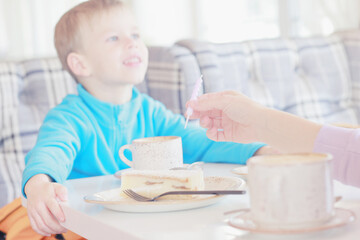 Fototapeta premium A 5-year-old boy blows out a candle on a birthday cake