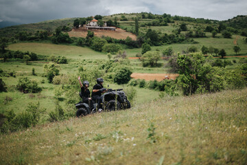 Two friends ride quad bikes through verdant countryside, highlighting adventure, nature, and...