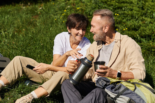 Active seniors enjoying a peaceful break during a mountain hike in nature beauty