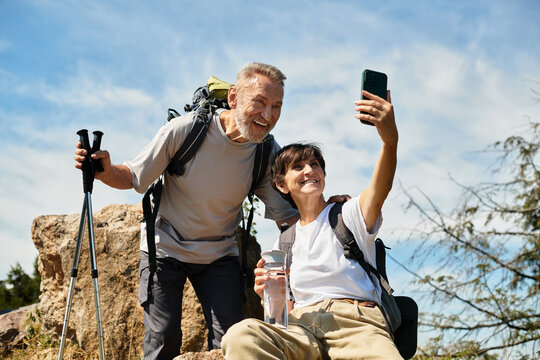 Senior couple enjoys a joyful moment while hiking in scenic mountains