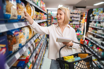 Woman shopping for groceries at supermarket aisle