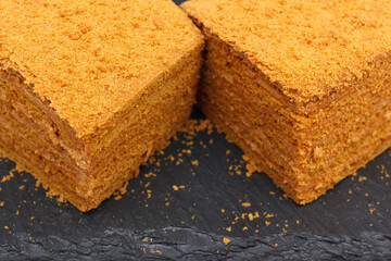 Homemade layered sweet cake with crumbs and cream, closeup view with selective focus.