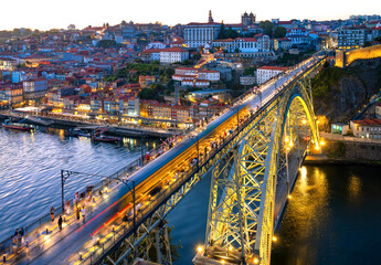 The bridge over the Douro River in Porto (Portugal) is one of the main attractions of the port city. Colorful panorama in the warm evening light after sunset, seen from the “Jardim do Morro.”