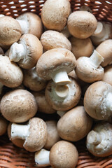 Fresh brown mushrooms piled in a woven basket ready for cooking in a kitchen setting