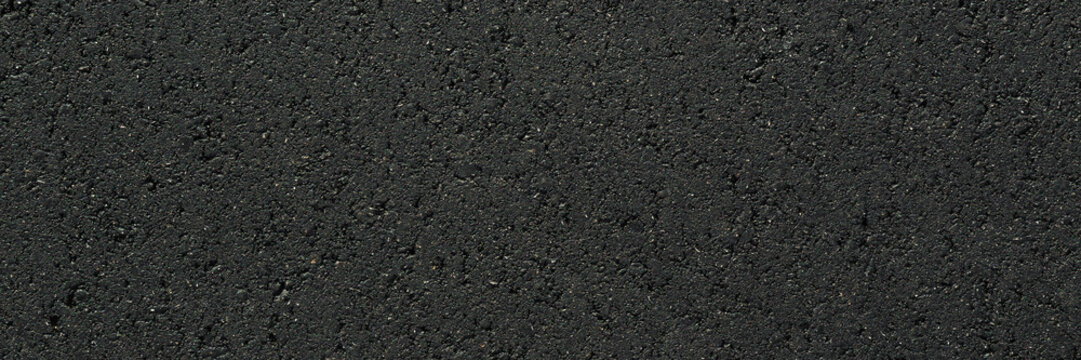 New dark black asphalt background. Closeup. Wide banner. Empty place for text. Top down view.