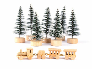 Kleine Holzeisenbahn vor künstlichem Wald freigestellt vor weißem Hintergrund