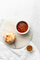 Overhead view of a plate of masa and pepper sauce, top view of food from northern nigeria masa waina rice cake and stew