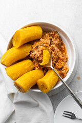 overhead view of Boiled ripe plantain with tomato scrambled eggs in a white bowl, top view of nigerian egg and plantain