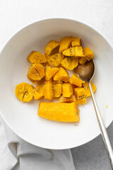 overhead view of Boiled ripe plantain in a white bowl, top view of nigerian cooked ripe plantain