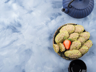 Matcha madeleine cookies with white chocolate frosting and sesame seeds
