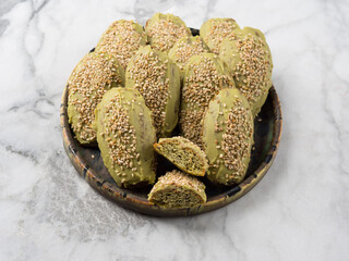 Matcha madeleine cookies with white chocolate frosting on marble background