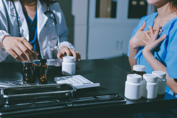 Female doctor holding a medicine bottle is checking the quality of medicine for any side effects the patient or not and recording patient information at the hospital. medical and health care concept
