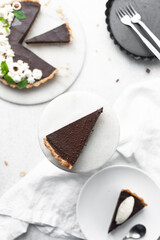Overhead view of a slice of chocolate tart on a white plate, top view of no bake chocolate tart on a white background