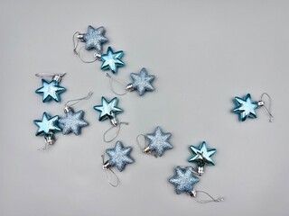 Blue Christmas star decorations scattered on a light surface, top view
