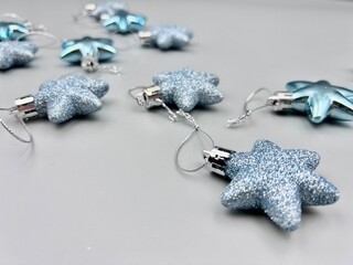 Blue Christmas star decorations scattered on a light surface, top view