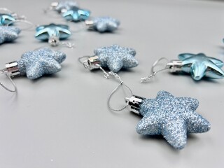 Blue Christmas star decorations scattered on a light surface, top view