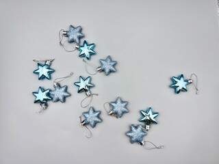Blue Christmas star decorations scattered on a light surface, top view