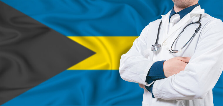 Bahamas healthcare concept. Male doctor on Bahamas flag. Doctor with crossed arms on Bahamas flag
