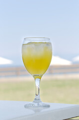Glass of juice and mango on the background of sea and blue sky close-up