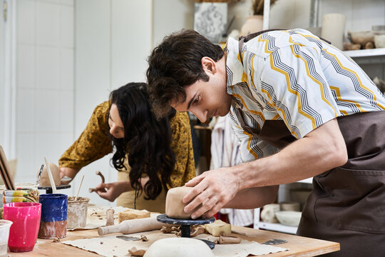 Young couple creates pottery together in a cozy arts studio, sharing laughter and love